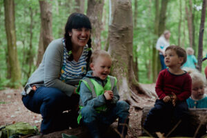 A photo of a woods practitioner laughing with two children